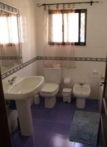 ein weißes Bad mit einem Waschbecken und einem WC in der Unterkunft Comporta beach house in Carvalhal
