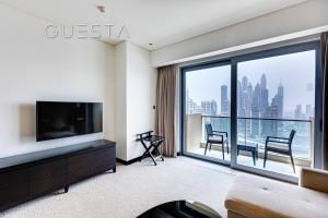 Una sala de estar con televisión y una gran ventana. en Marina Mall Apartments, Dubai Marina, en Dubái