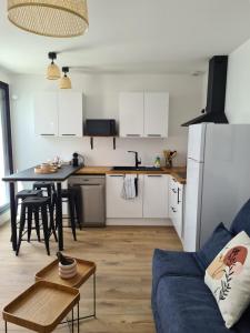 uma cozinha e sala de estar com um sofá e uma mesa em Location LA REBELLE - LA ROCHELLE B em La Rochelle