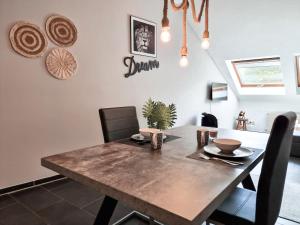 uma sala de jantar com uma mesa de madeira e cadeiras em Holiday Home Alessia em Bollendorf