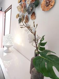 a vase with flowers on a white wall at Villa Ginevra in Porto Cesareo