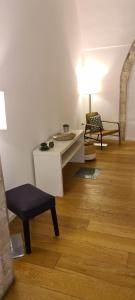 ein Wohnzimmer mit einem Tisch und einem Stuhl in der Unterkunft BorgoAntico34 - Luxury Room in Molfetta