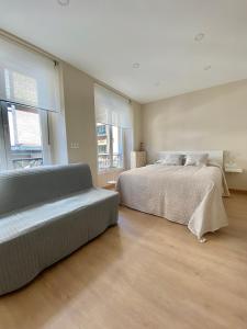 1 dormitorio con 2 camas y ventana grande en Alojamientos Muelle de Gijón en Gijón