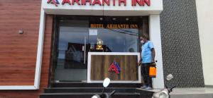 a man standing in front of a store window at Arihanth Inn in Vellore