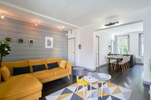 uma sala de estar com um sofá amarelo e uma mesa em Locations Boulogne sur mer, 4 chambres, Tamaris em Boulogne-sur-Mer
