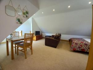 a bedroom with a bed and a table and a chair at Shepherds Loft in Ullenhall