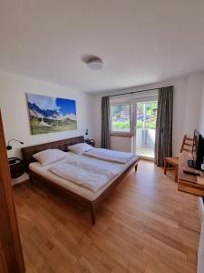 um quarto com uma cama e uma grande janela em Lift-Residenz Scheffau em Scheffau am Wilden Kaiser