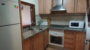 uma pequena cozinha com um lavatório e um micro-ondas em PRECIOSO APARTAMENTO JUNTO AL MAR em Isla Canela