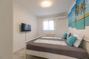 sypialnia z dużym łóżkiem z niebieskimi poduszkami w obiekcie Apartments Tina Stinjan w Puli