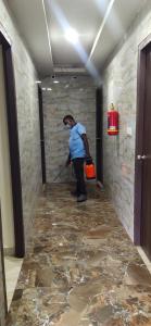 a woman standing in a hallway with a broom at Arihanth Inn in Vellore