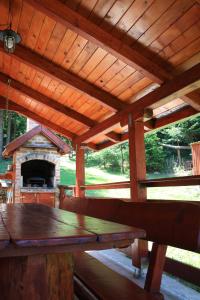 a wooden pavilion with a table and a fireplace at Chalet Woody in Stara Sušica