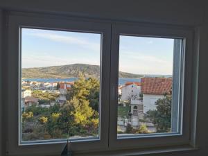 a window with a view of a city at Apartment Pinia in Primošten