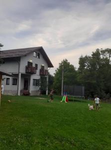 a group of children playing in a yard in front of a house at Casa Moșoiu in Bran