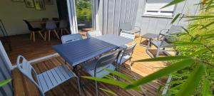 einen blauen Tisch und Stühle auf einer Veranda in der Unterkunft LE POULORIO TERRASSE - T3 RDC - 2 salles de douches ByLocly in Lorient