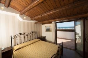 a bedroom with a bed and a view of the ocean at Hotel Aliai in Sciacca