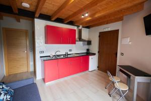 a kitchen with red cabinets and a sink in a room at La besñada in Cangas de Onís