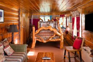 una sala de estar con una cama en una cabaña de madera en Gold Mountain Manor, en Big Bear City