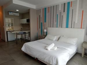 a bedroom with a large white bed with towels on it at Vizion Suites by D&G in Carilo +51 photos