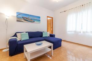 a living room with a blue couch and a table at Lovely Flat Santa Catalina Park in Las Palmas de Gran Canaria