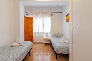 ラスパルマス・デ・グランカナリアにあるLovely Flat Santa Catalina Parkのベッドルーム1室(ツインベッド2台、窓付)