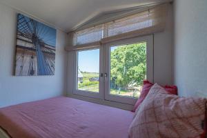 a bedroom with a bed and a large window at De Tweede Brug in Echten