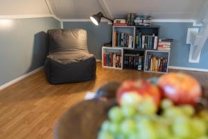 una stanza con una sedia e un tavolo con mele di De Tweede Brug a Echten