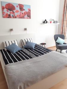 een bed met zwarte en witte lakens en een blauwe stoel bij Central Belvedere Apartman in Boedapest