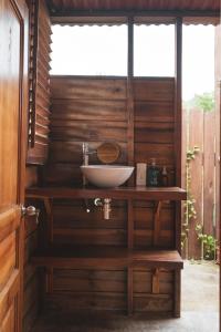 baño con lavabo en una pared de madera en La Casita del Bosque, en Santa Marta