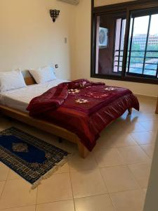 - une chambre avec un lit et une couverture rouge dans l'établissement Résidence Caprice Palace Hivernage, à Marrakech