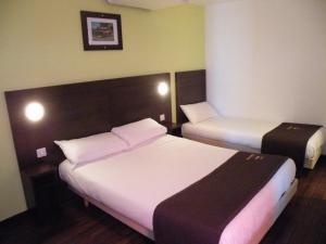 a room with two beds in a hotel room at Enzo Hotel Mulhouse Sud Morschwiller By Kyriad Direct in Morschwiller-le-Bas
