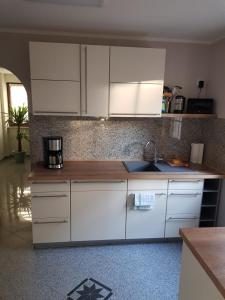 a kitchen with white cabinets and a sink at Inselblüte 2 in Werder