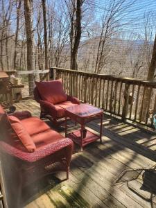 2 sillas y una mesa en una terraza en Treehouse Cathedral in Blue Ridge Mountains, NC, en Burnsville