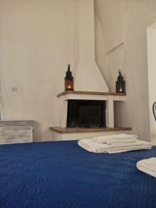 1 dormitorio con chimenea y 1 cama con manta azul en Delcicer casa vacanze o camera privata, en Galatina