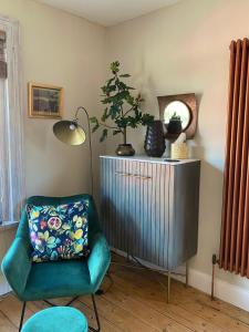 una sala de estar con una silla verde y una lámpara. en Fig Tree Flat - Recently Renovated en Glastonbury