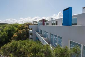 an external view of a building with trees at Vizion Suites by D&G in Carilo