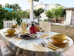 einen Tisch mit einem Teller Essen und Gläsern darauf in der Unterkunft Xenìa - Villa con Piscina Privata in Agrigento