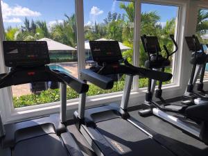 a gym with three treadmills in front of a window at Dolphin Cove in Freeport