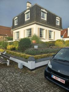 ein schwarzes Auto, das vor einem Haus geparkt ist in der Unterkunft Villa Elsjes Droom in Koksijde