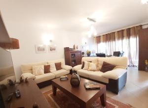 uma sala de estar com dois sofás e uma mesa de centro em Casa Sal Sol Sul - casa de férias perto da praia da Manta Rota em Vila Nova de Cacela