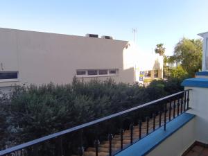 イスラ・カネラにあるAcogedor apartamento a 50 metros de la playaの塀と植物のある建物のバルコニー