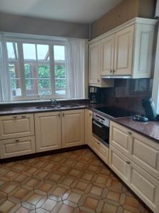 eine Küche mit weißen Schränken und einem Herd mit Backofen in der Unterkunft Villa Elsjes Droom in Koksijde + 4 Fotos