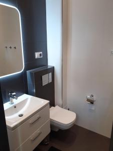 ein Badezimmer mit einem weißen WC und einem Waschbecken in der Unterkunft Apartament Sobieskiego in Nowy Sącz