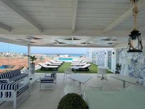 een patio met witte meubels en uitzicht op een zwembad bij DESIGN SUITES Boutique Hotel - Adults Only in Santa Maria