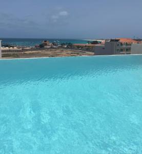a large blue swimming pool next to a beach at DESIGN SUITES Boutique Hotel - Adults Only in Santa Maria