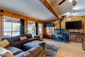 a living room with a couch and a flat screen tv at Bear Creek Cottage in Joseph
