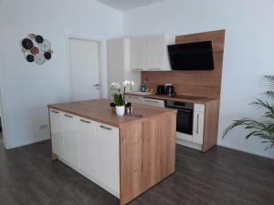 a kitchen with white cabinets and a wooden counter top at Ferienwohnungen Winzergasse in Purbach am Neusiedlersee