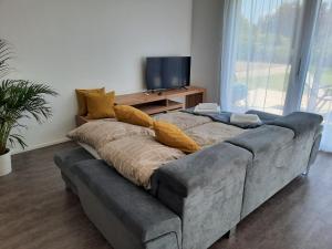 a large couch in a living room with a television at Ferienwohnungen Winzergasse in Purbach am Neusiedlersee