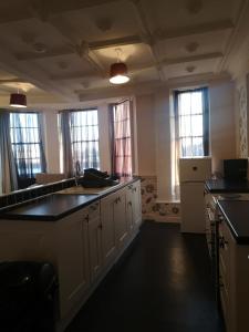 a kitchen with white cabinets and black counter tops at Penthouse Flat with River View, 1C in Great Yarmouth
