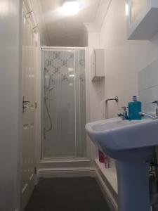 a white bathroom with a shower and a sink at Penthouse Flat with River View, 1C in Great Yarmouth