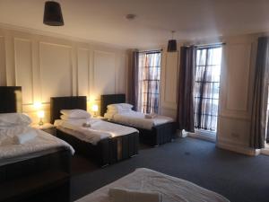 a hotel room with two beds and two windows at Penthouse Flat with River View, 1C in Great Yarmouth